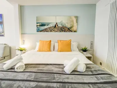 a bedroom with a large white bed with orange pillows at The Green Oasis by Hello Homes Sitges in Sitges