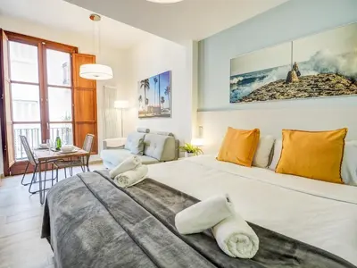a bedroom with a large bed and a dining room at The Green Oasis by Hello Homes Sitges in Sitges