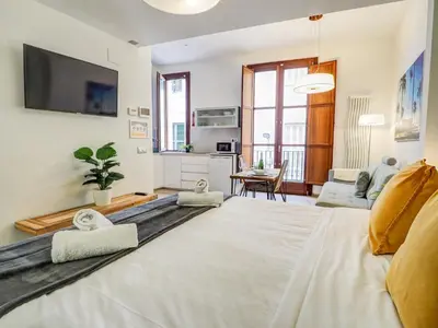 a living room with a couch and a tv at The Green Oasis by Hello Homes Sitges in Sitges