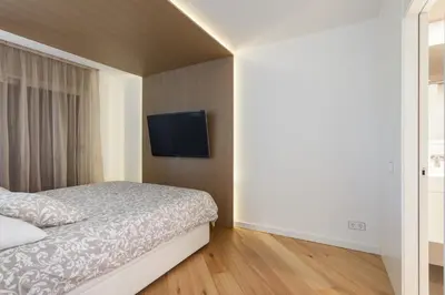 a bedroom with a bed and a flat screen tv at HHBCN Beach Apartment Gava #2 in Gavà