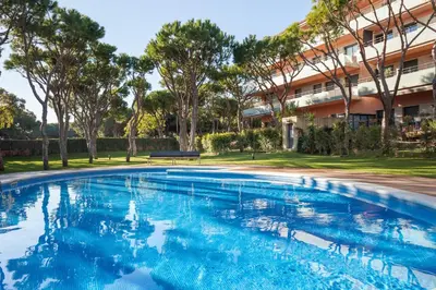 a swimming pool in front of a building at HHBCN Beach Apartment Gava #2 in Gavà