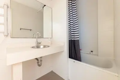 a bathroom with a sink and a mirror and a tub at Housalia Sagrada Familia in Barcelona