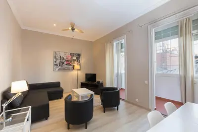 a living room with a black couch and chairs at Housalia Sagrada Familia in Barcelona