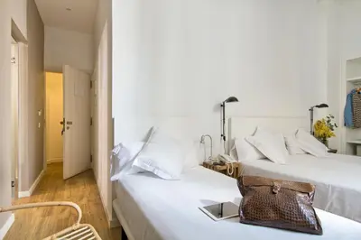 a hotel room with two beds and a purse on the bed at Som Nit Born in Barcelona