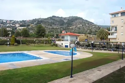 a resort with a swimming pool and a mountain at La Marina Sea Front by Hello Homes Sitges in Sitges
