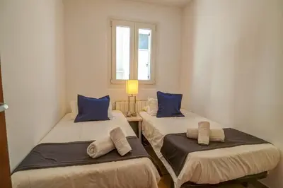 two twin beds in a room with a window at La Marina Sea Front by Hello Homes Sitges in Sitges