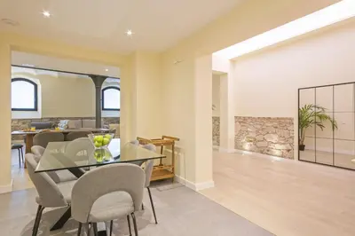 a dining room with a glass table and chairs at Ola Living Diagonal II Apartments in Barcelona