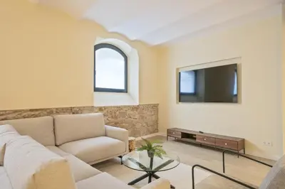 a living room with a couch and a tv at Ola Living Diagonal II Apartments in Barcelona
