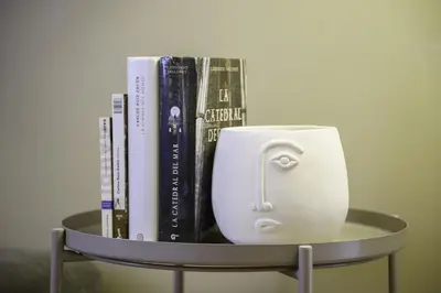 a shelf with books and a cup on top of it at Ola Living Diagonal II Apartments in Barcelona