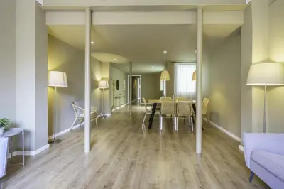 a dining room and living room with a table and chairs at Ola Living Diagonal II Apartments in Barcelona