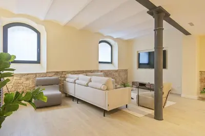 a living room with a couch and a chair at Ola Living Diagonal II Apartments in Barcelona