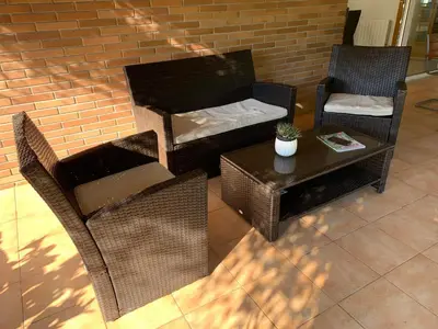 a patio with chairs and a table and a brick wall at Villa Dacar in Cubelles