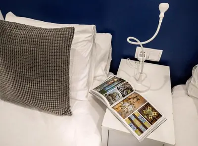 a bed with a pillow and a book on a side table at DUPLEX NEAR THE BEACH Barceloneta in Barcelona