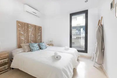 a white bedroom with a large bed with towels on it at vilasardemarlux3 in Vilassar de Mar