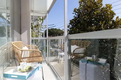 a balcony with wicker chairs and a table at vilasardemarlux3 in Vilassar de Mar