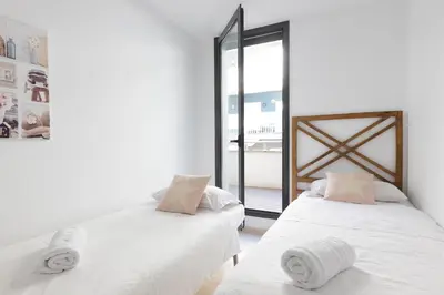 two beds in a room with a window at vilasardemarlux3 in Vilassar de Mar