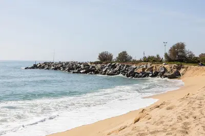 a beach with a bunch of rocks and the ocean at vilasardemarlux3 in Vilassar de Mar