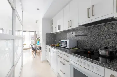 a kitchen with white cabinets and a stove top oven at vilasardemarlux3 in Vilassar de Mar