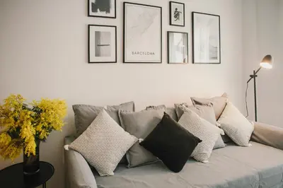 a living room with a gray couch with pillows at BBarcelona Central Boutique Apartments in Barcelona