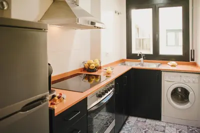 a kitchen with a stove top oven next to a washing machine at BBarcelona Central Boutique Apartments in Barcelona