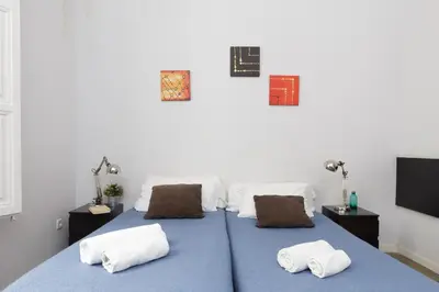 a bedroom with a blue bed with two pillows at Key Plaza Universidad - Gran Via in Barcelona