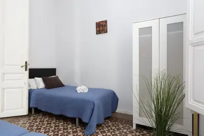 a bedroom with a blue bed and a plant at Key Plaza Universidad - Gran Via in Barcelona