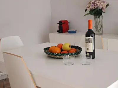 a bottle of wine and a bowl of fruit on a table at Vinyet Sitges in Sitges