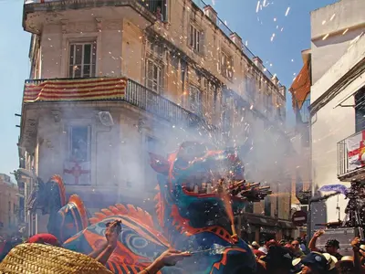 a crowd of people standing in front of a building with fireworks at Vinyet Sitges in Sitges
