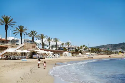 two children walking on the beach near the ocean at Vinyet Sitges in Sitges