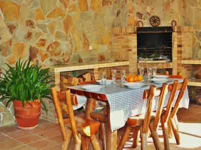 a dining room with a table with chairs and a fireplace at Villa in Sant Pol near Crystal Beach in San Pol de Mar