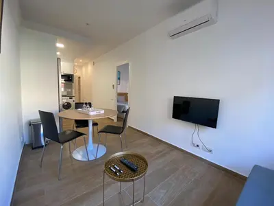 a living room with a table and chairs and a tv at VIU BARCELONA BERTRAN in Barcelona