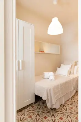 a bedroom with two beds and a white cabinet at Urban Apartments in Barcelona