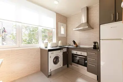 a kitchen with a washing machine and a washer at Urban Apartments in Barcelona