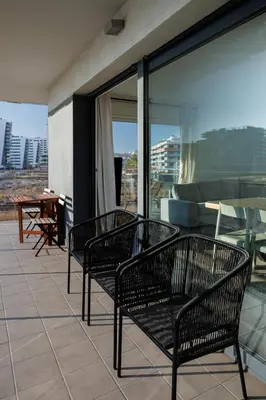 a balcony with three benches and a piano on a building at Gran Apartmento Playa Badalona in Badalona