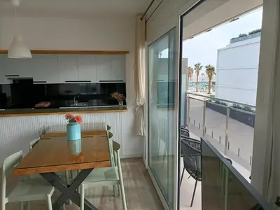 a kitchen and dining room with a table and a balcony at Gran Apartmento Playa Badalona in Badalona