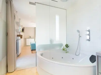 a white bathroom with a tub in a room at Kronos on the Beach Attic Suite in Barcelona