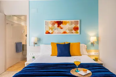 a bedroom with a bed with a glass of wine at Kronos on the Beach suite 1 in Barcelona