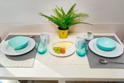 a table with plates and bowls and a plant on it at Kronos on the Beach suite 1 in Barcelona