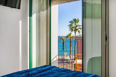 a bedroom with a bed and a view of the ocean at Kronos on the Beach suite 3 in Barcelona