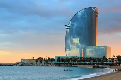 a building on the beach with people in the water at FELIP - Spacious and quiet apartments & one with Terrace in Barcelona