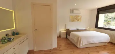 a white bedroom with a bed and a window at Villa Vicente in Canyelles