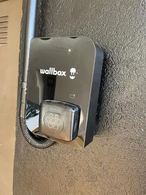a cell phone is plugged into a wall box at Villa Vicente in Canyelles