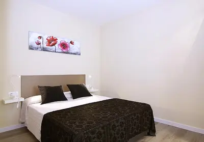 a bedroom with a bed and a painting on the wall at MUNNE - Spacious apartments next to FC Barcelona in Barcelona