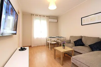 a living room with a couch and a table at MUNNE - Spacious apartments next to FC Barcelona in Barcelona