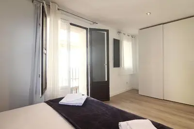 a bedroom with a bed and a large window at MIQUEL ANGEL - Apartments & one with private terrace in Barcelona