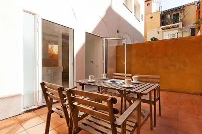 a wooden table and chairs on a balcony at MIQUEL ANGEL - Apartments & one with private terrace in Barcelona