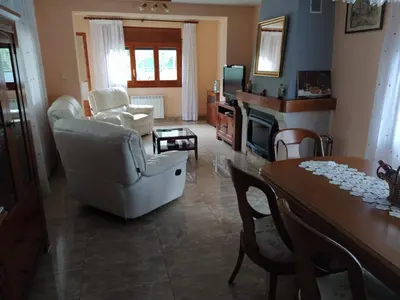a living room with a table and chairs and a dining room at Casa en Parque Natural del Montseny. in Santa María de Palautordera