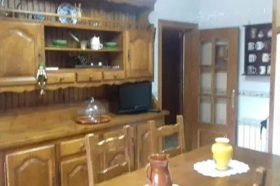 a kitchen with wooden cabinets and a wooden table at Casa en Parque Natural del Montseny. in Santa María de Palautordera