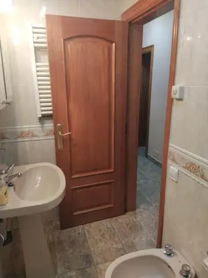 a bathroom with a sink and a toilet and a wooden door at Casa en Parque Natural del Montseny. in Santa María de Palautordera
