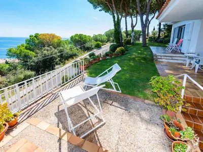 a pair of white chairs sitting on a patio at Holiday Home La Marina Blanca by Interhome in San Pol de Mar